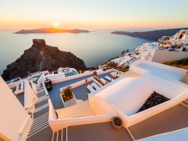 Santorini Adası, Yunanistan 'da beyaz mimari. Gün batımında güzel bir deniz manzarası. Seyahat ve yaz tatili konsepti