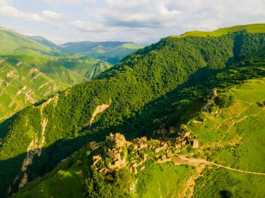 Dağıstan, Rusya 'daki terk edilmiş Gamsutl dağ köyündeki eski taş evler. Hava görüntüsü. Gün batımında yaz manzarası. Meşhur seyahat yeri