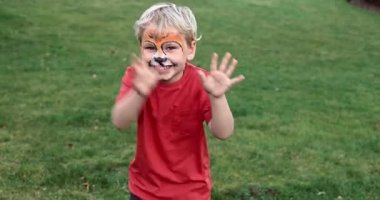 Cute little boy with face paint. Face painting, kid painting face at the birthday party or on holidays