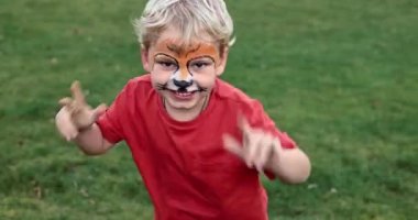 Cute little boy with face paint. Face painting, kid painting face at the birthday party or on holidays