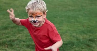 Cute little boy with face paint. Face painting, kid painting face at the birthday party or on holidays