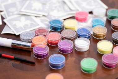 Doğum günü partisinde çocuklar için parıldayan parlak dövmeler yapmak için masadaki tüm malzemeler hazır. Vücut sanatı