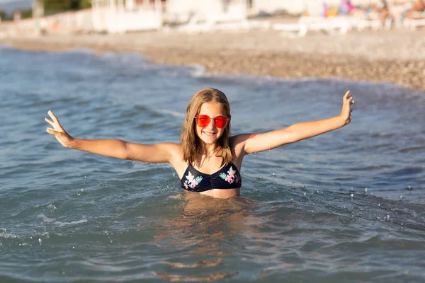 十几岁的女孩戴着粉色太阳镜 在海滩上玩乐 玩海浪和飞溅 暑期休闲活动的乐趣 — 图库照片