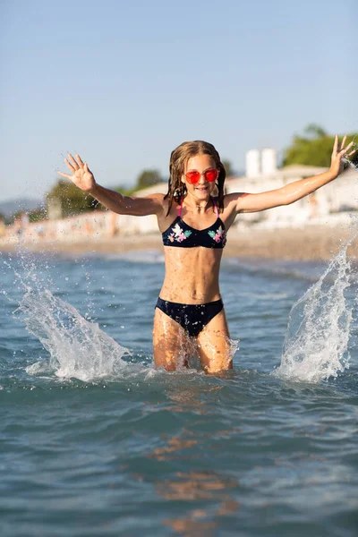 十几岁的女孩戴着粉色太阳镜 在海滩上玩乐 玩海浪和飞溅 暑期休闲活动的乐趣 — 图库照片