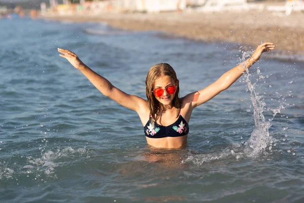 선글라스를 해변에서 파도와 물장구를 즐거운 시간을 보내고 있습니다 즐거운 여름날의 스톡 이미지