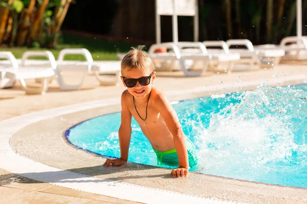 Glücklicher Kleiner Junge Der Sich Pool Des Resorts Vergnügt Sommerurlaub lizenzfreie Stockfotos