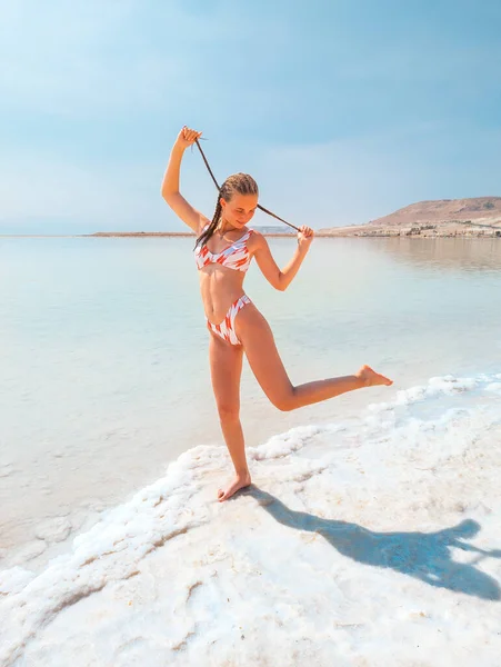 死海塩の結晶形成海岸線で水着で美しい少女は 明確なシアン緑色の水Einボケビーチ イスラエルで 死海リゾートの休日 — ストック写真