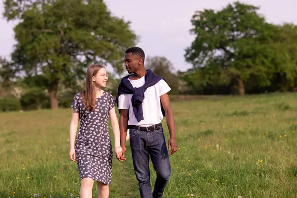 Genç bir çift, açık havada yaz gününün tadını çıkarıyor. Siyah bir adam ve beyaz bir kadın, doğal bir bahçe bahçesinde birlikte. Romantizm, sevgi ve çeşitliliği barışçıl, güneşli bir ortamda ifade ediyorlar.