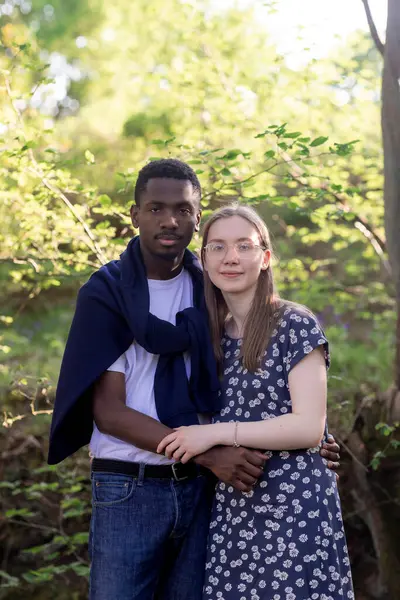 Genç bir çift, açık havada yaz gününün tadını çıkarıyor. Siyah bir adam ve beyaz bir kadın, doğal bir bahçe bahçesinde birlikte. Romantizm, sevgi ve çeşitliliği barışçıl, güneşli bir ortamda ifade ediyorlar.
