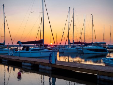 Rıhtımın şafak vakti iskelesi yelkenli yatlarla dolu, sakin, sakin ve huzur dolu deniz manzaralı.