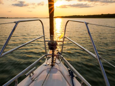 Günbatımı ışığında yelken açan yat, gölde yelken açan.