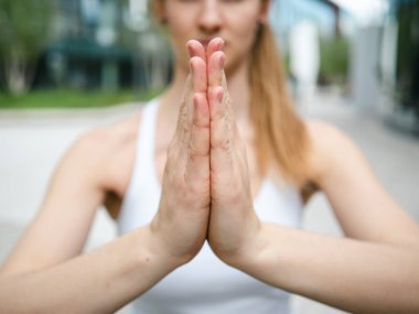 Yoga yapan ve namaste ya da anjali mudra yapan genç bir kadın.