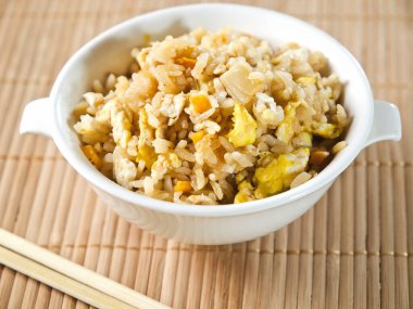 Yumurta ve istiridye ile servis edilen beyaz kase kızarmış pilav.