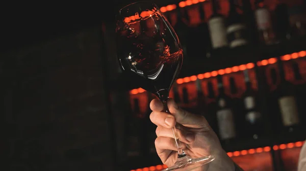 Elinde bir kadeh kırmızı şarap.