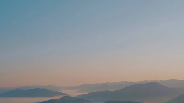 Gün doğumunda sisli Karpat Dağları.