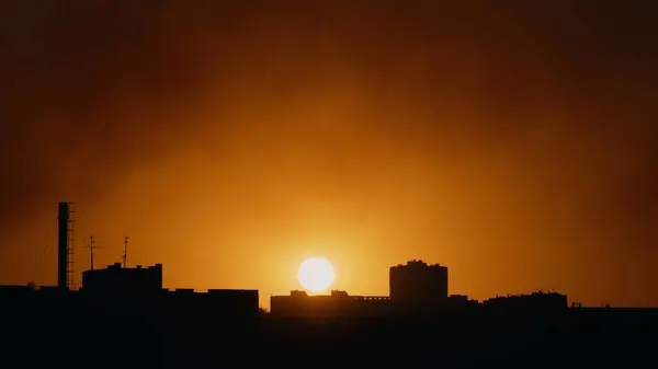 Gün batımı ve şehrin çatılarının manzarası.