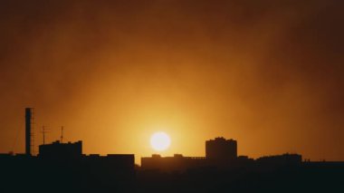 Gün batımı ve şehrin çatılarının manzarası.