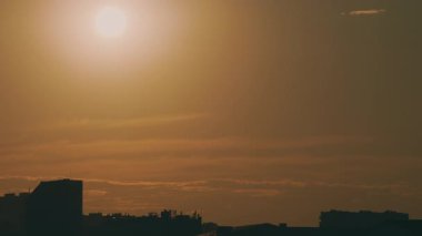 Güneş ve şehrin çatılarının manzarası.