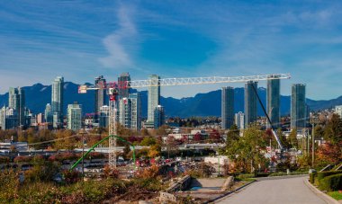 A new construction site in downtown Burnaby, opposite a residential area with a mountain range in the background clipart