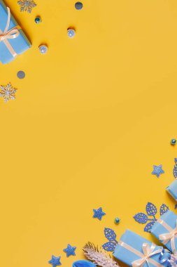 Hediyeler, kağıt toplar ve süslemelerden oluşan düz bir Noel kompozisyonu. Ukrayna sarısı mavi renkler. Boşluğu kopyala.