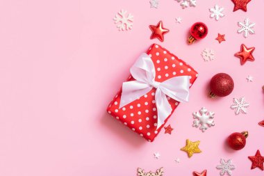 Noel hediyesi pembe arka planda yatıyordu. Dekorasyonlu üst görünüm xmas hediye kutusu.