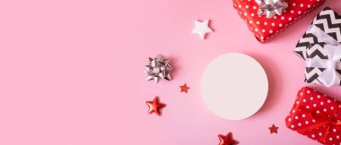 Noel, yeni yıl ve satış etkinliği konsepti için ürün geçmişi. Pembe arka plan görünümlü kurdeleli hediye kutuları.