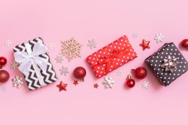 Noel hediyeleri pembe arka planda yatıyordu. Dekorasyonlu üst görünüm xmas hediyeleri.