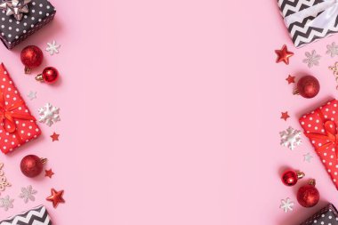 Noel hediyeleri pembe arka planda yatıyordu. Dekorasyonlu üst görünüm xmas hediyeleri.