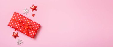 Pembe arka planda, Noel hediyesi düz bir pankart vardı. Süslü Noel hediyesi kutusu. Boşluğu kopyala.