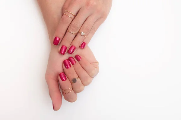 带戒指的女性手指上闪烁着的活洋红色泽的修指甲凝胶抛光剂 — 图库照片