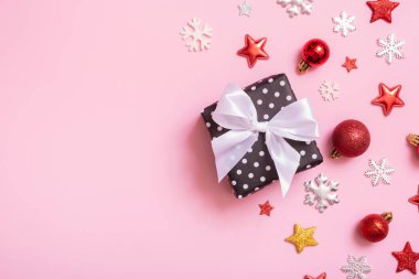 Noel hediyesi pembe arka planda yatıyordu. Dekorasyonlu üst görünüm xmas hediye kutusu.