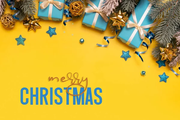 Veselé Vánoce Text Žlutém Pozadí Borovicemi Modré Dárky Slavnostní Dekorace — Stock fotografie