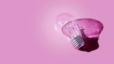 Pembe arka planda ışık olan cam lamba. Yaratıcı fikir ya da başlangıç konsepti. Monokrom görüntüler. Yüksek kalite 4k görüntü