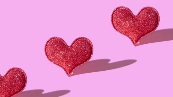 ハードシャドウでピンクの背景に赤い輝きのハート型を持つパターン バナーだ バレンタインデーミニマリストのシンボル 高品質4K映像 — ストック動画