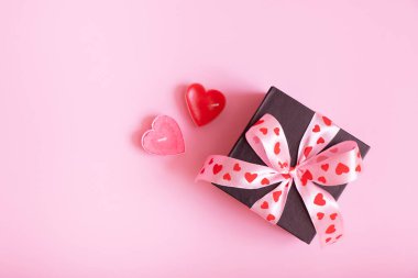 Pembe arka planda fiyonklu hediye kutusu. Sevgililer Günü hediyesi düzdü.