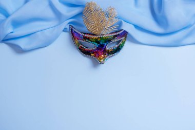 Festive face mask for carnival or masquerade celebration on colored background.