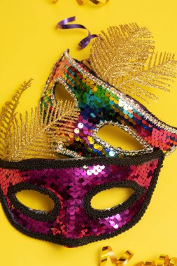 Festive face mask for carnival celebration or masquerade on colored background.