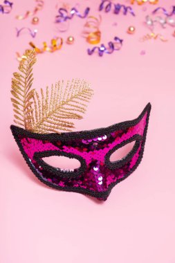 Festive face mask for carnival celebration or masquerade on colored background.