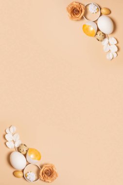 Monochrome flat lay Easter eggs composition decoration with twigs and flowers. Easter still life beige.