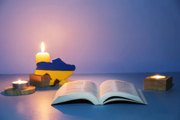 Ukraine map and Holy Bible with Visible mending lighting on colored background