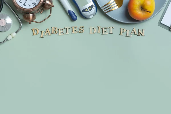 Diabetes Diet Plan text. Stethoscope, glucometer and plate with copy space on colored background.