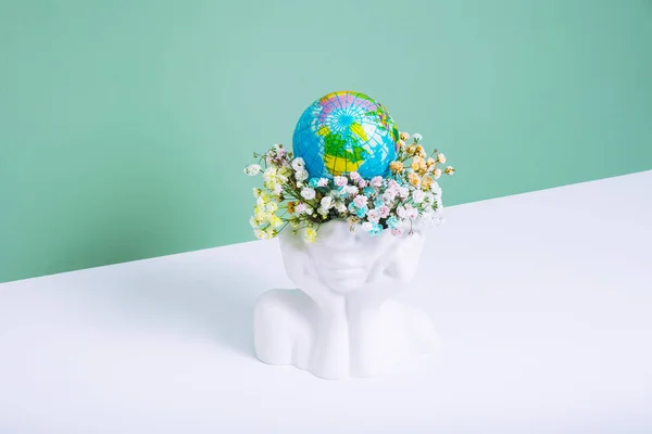 stock image Save the planet, Earth day concept. Creative plaster vase head-shape with flowers and world globe.