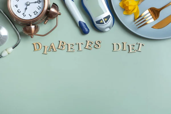 Diabetes Diet text. Stethoscope, glucometer and plate with copy space on colored background.