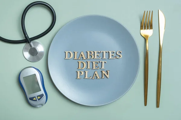 Diabetes Diet Plan text. Stethoscope, glucometer and plate with cutlery on colored background.