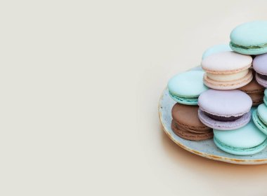 Bej bir arka planda, farklı pastel renkte pasta makaronları ve kopyalama alanı var..