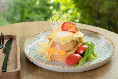 Beşamel sosunun altında yumurta, jambon ve peynirli tost. Restoranda nefis bir kahvaltı..