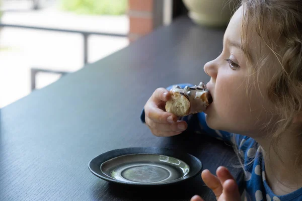 Egy Kislány Fánkot Eszik Egy Kávézóban Ízlik Édes Étel — Stock Fotó