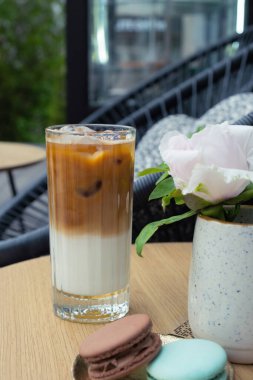 Kafe masasının arka planında bardakta buzlu latte kahve. Yaz taze kahve..