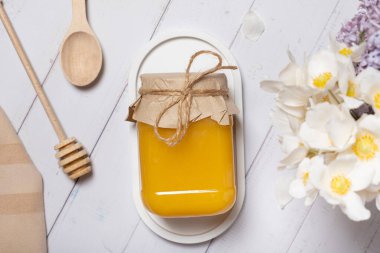 Ballı kavanoz ve çiçekli ahşap arka plan manzaralı, düz yatıyordu..