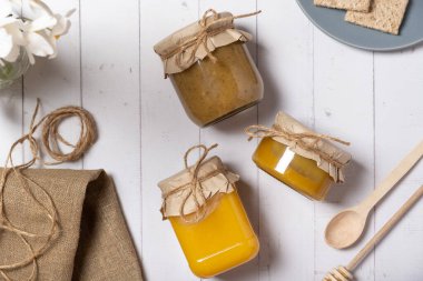 Ballı ve fındıklı kavanozlar ahşap arka plan manzaralı bal, düz uzanmış.